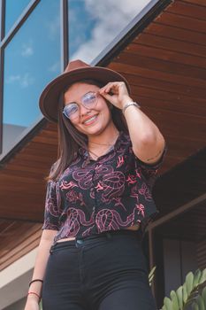Smiling woman in glasses and hat posing outdoors in Managua, Nicaragua.