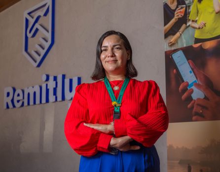 Woman Posing by Remitly Logo on Wall