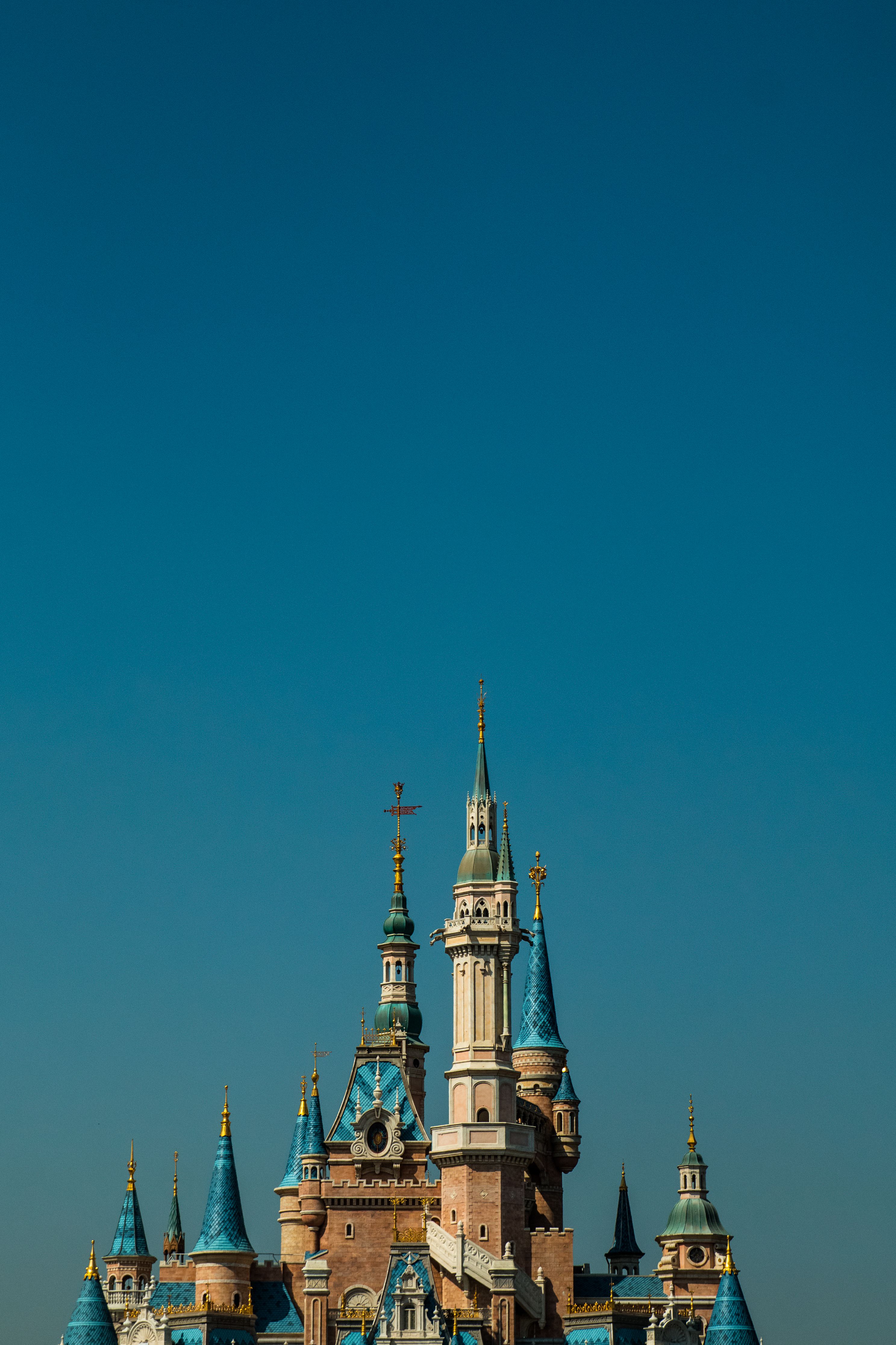 Elegant castle towers rise against a deep blue sky, showcasing a beautiful architectural facade.