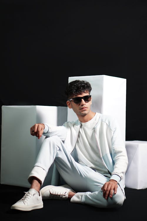 Young Man Posing near Cubes on Black Background