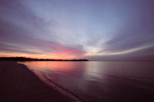 A tranquil ocean sunrise at Cove Island Park with vivid colors reflecting on calm waters.