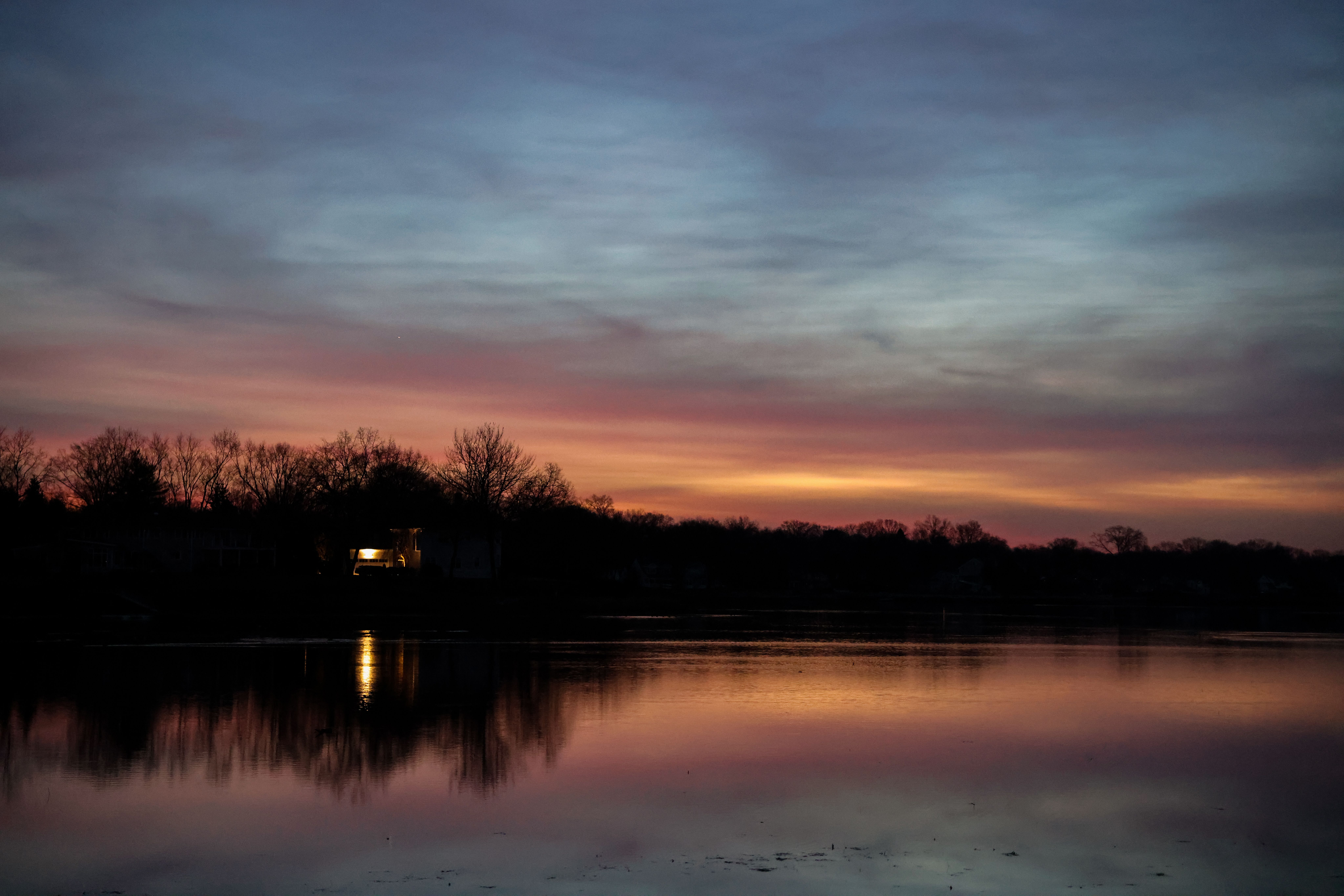 Silhouetted Trees on the Shore of a Body of Water at Sunset · Free ...
