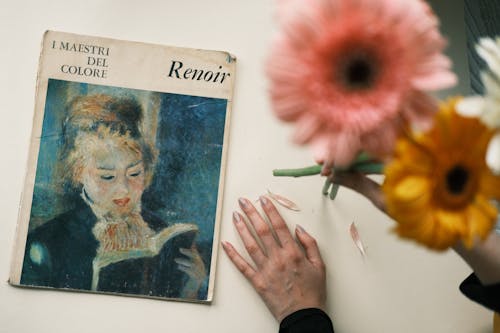 Flowers and a Hand of a Woman next to a Painting 