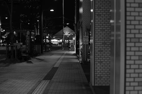 Black and White Picture of a Pavement in City at Night 