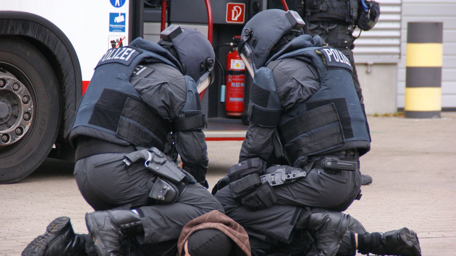 German police in full gear detain a suspect in an urban area in Hamburg.