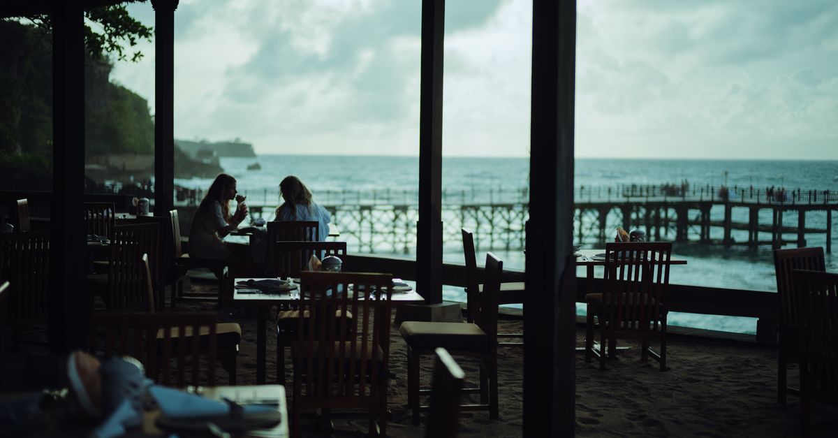 cliffside wooden café overlooking Bingin Beach with a laptop on a wooden table