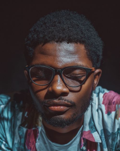 Free A thoughtful close-up portrait of a man with eyeglasses, eyes closed, in Abuja. Stock Photo