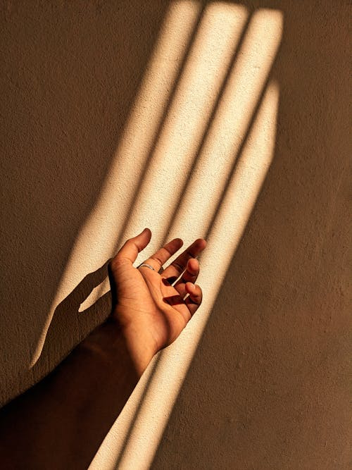 Close-up of Hand in Light on Wall Background