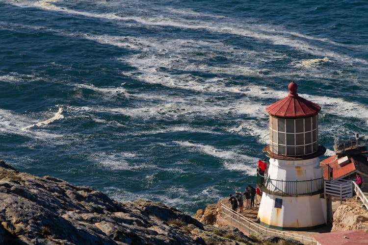 Lighthouse On Rocks By Sea Shore