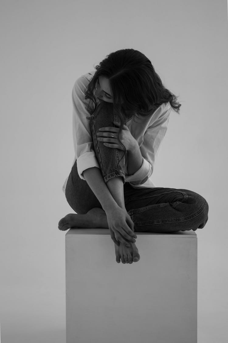 Woman Sitting On Cube In Studio