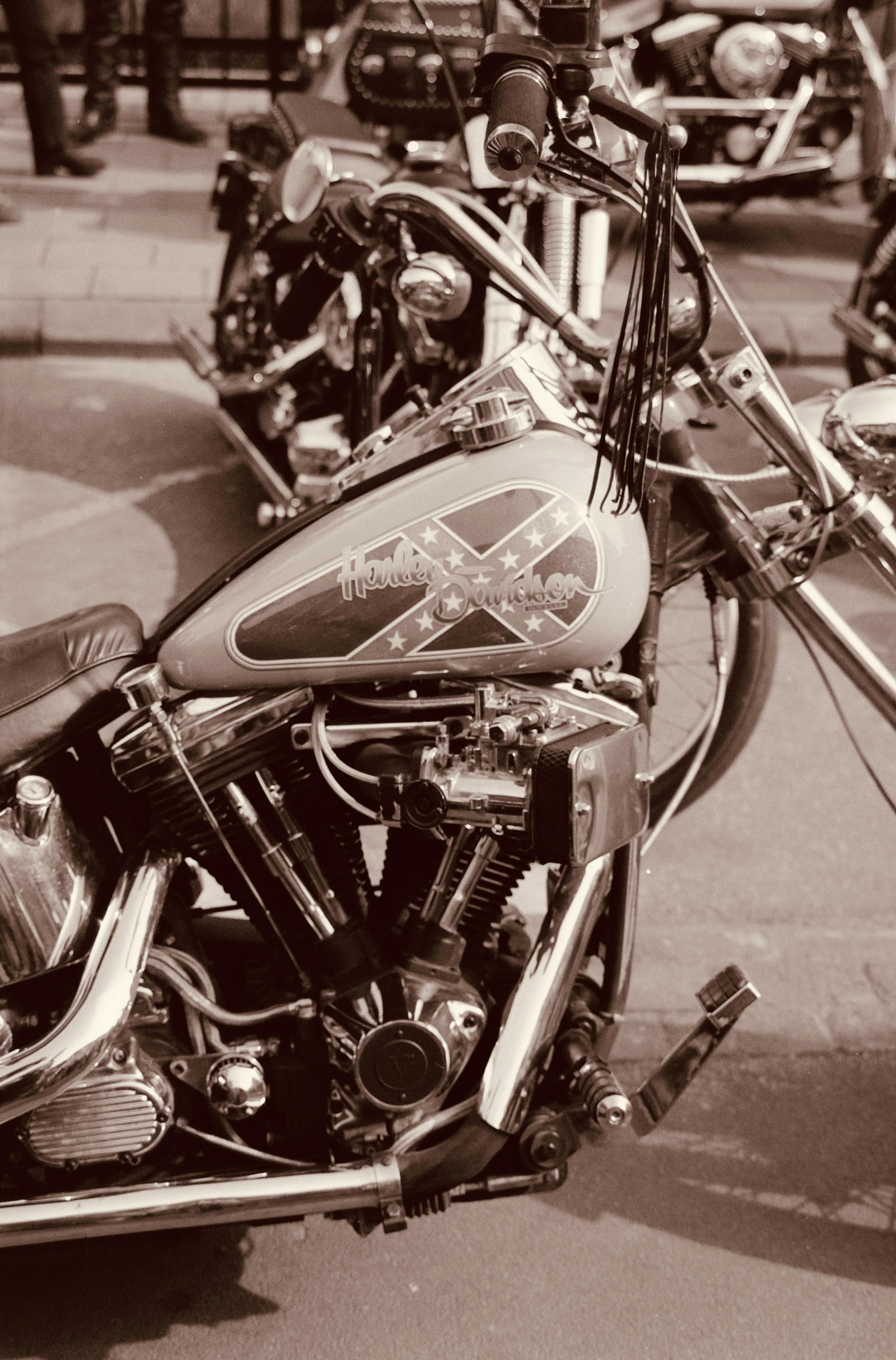 Vintage Harley Davidson motorcycle on a city street in sepia tone, evoking a classic feel.