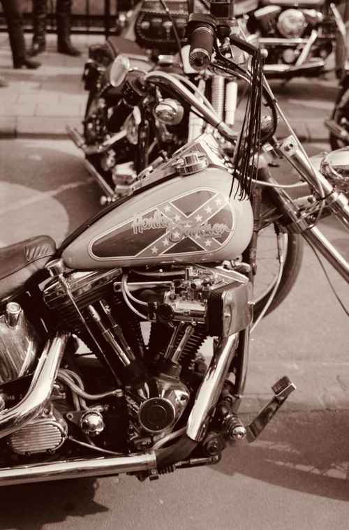 Free Vintage Harley Davidson motorcycle on a city street in sepia tone, evoking a classic feel. Stock Photo