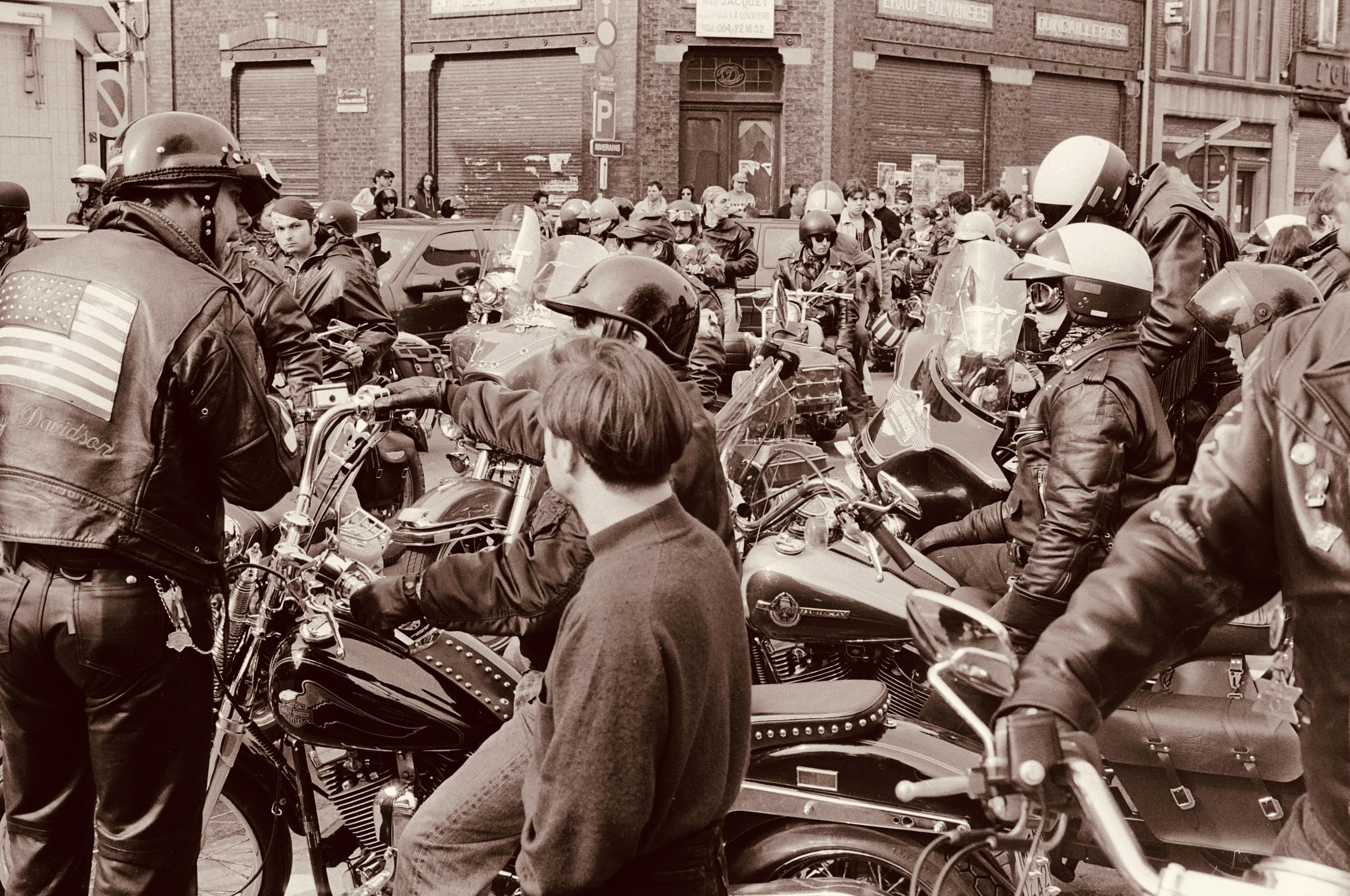 Biker community gathering in an urban setting with motorcycles and riders in leather attire.
