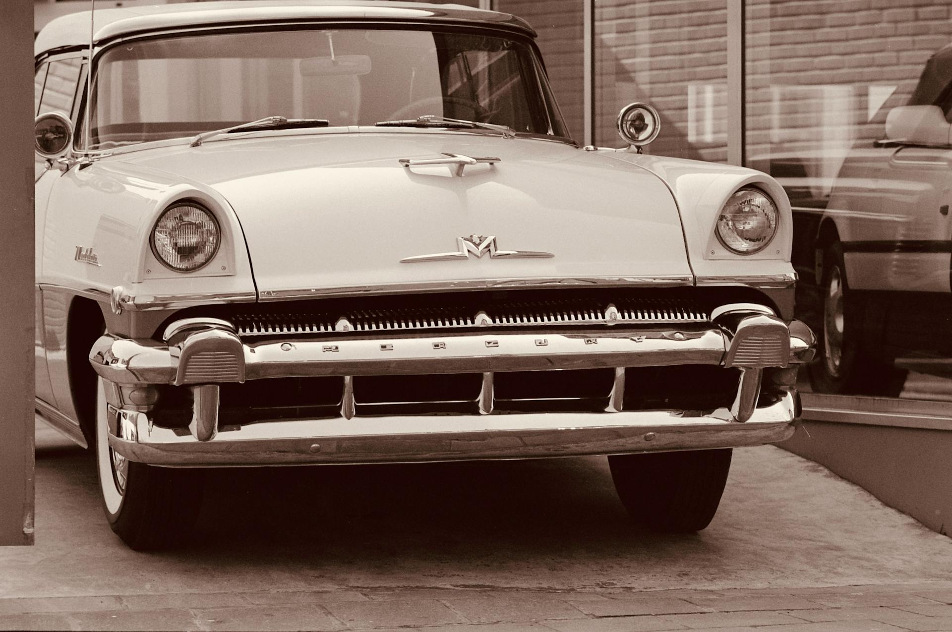 Sepia-toned vintage Mercury Montclair in a nostalgic setting, capturing classic automotive design.