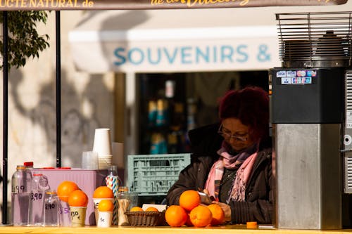 Woman Selling Fresh Orange Juice on a Street in City 