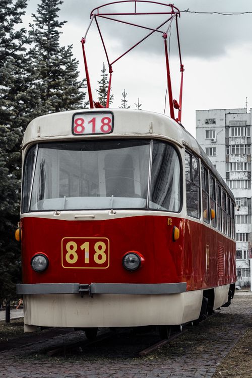 Free A classic red tram with number 818 in a winter urban landscape and snowy pine trees. Stock Photo