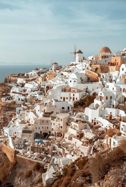Stunning aerial view of Santorini's iconic white buildings and blue sea, showcasing traditional Greek architecture.