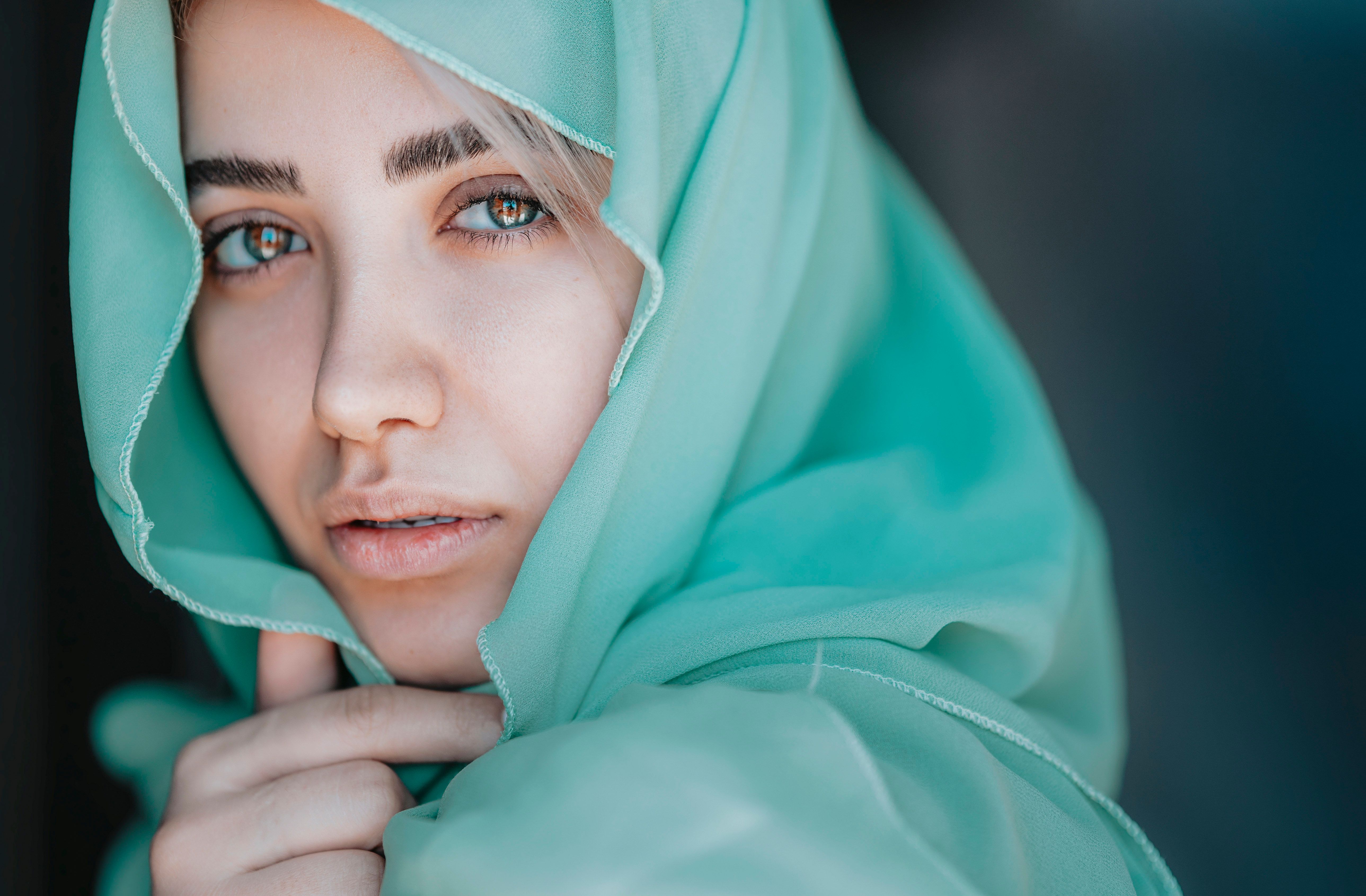 Captivating portrait of a woman embracing fashion with a teal headscarf.