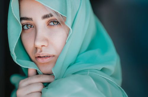 Free Captivating portrait of a woman embracing fashion with a teal headscarf. Stock Photo