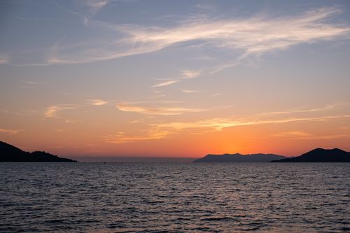Free Peaceful sunset with vibrant sky and tranquil sea view creating a serene landscape. Stock Photo