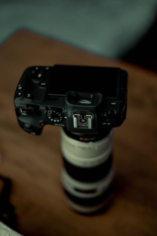 Free A close-up shot of a digital camera resting on a lens, showcasing photography equipment essentials. Stock Photo