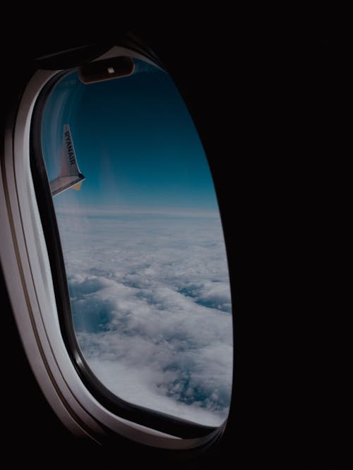 Clouds behind Flying Airplane Window