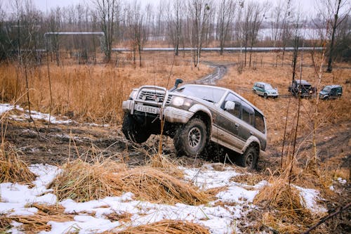 A suv driving through a muddy field