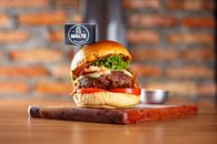 Close-up of a mouthwatering gourmet burger with fresh lettuce and tomato, perfect for food photography.