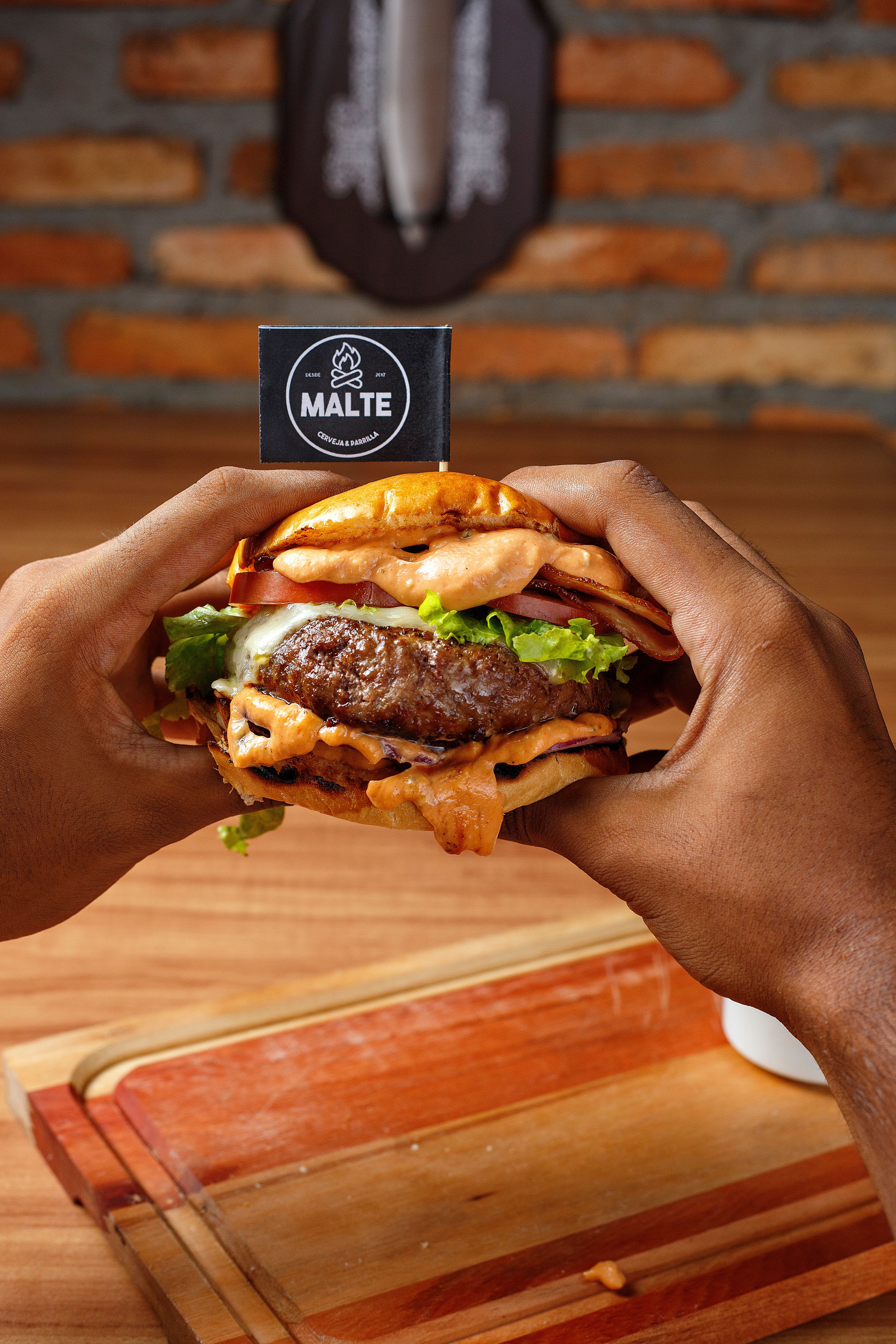 Close-up of a delicious burger being held, perfect for food lovers and restaurant enthusiasts.