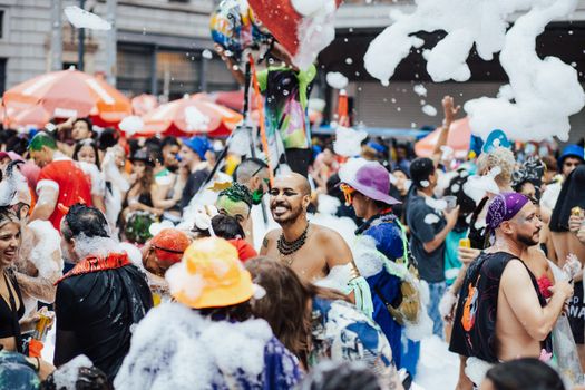 Energetic crowd enjoying a lively foam party outdoors, filled with joy and fun.