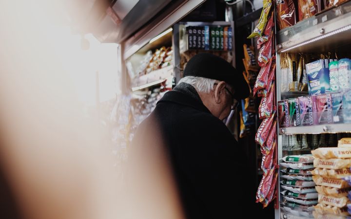 Candid shot of a man browsing snacks at a grocery store aisle.
