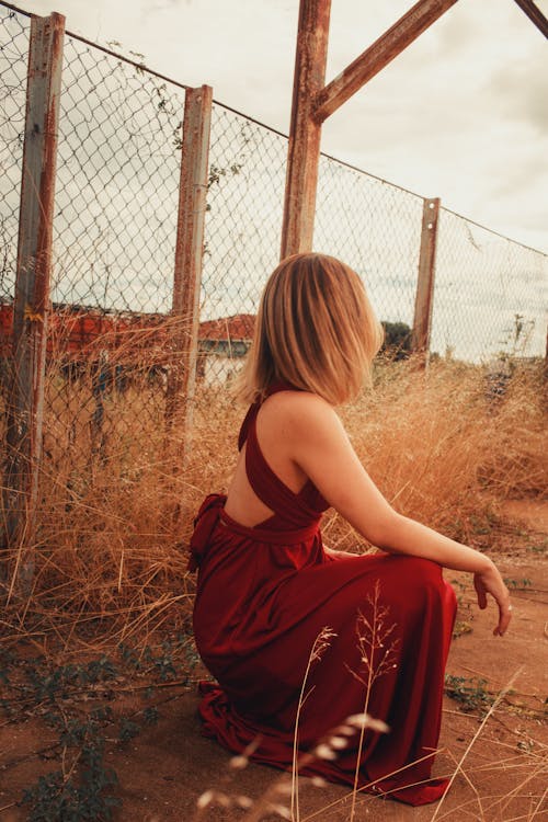 Woman Sitting near Fence