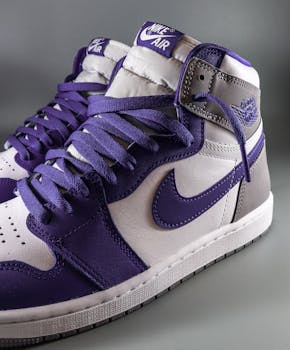 Detailed close-up of stylish purple and white Nike Air Jordan sneakers showcasing unique streetwear fashion.