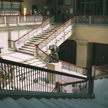 Elegant staircase in a Chicago museum with artistic sculptures and soft lighting.