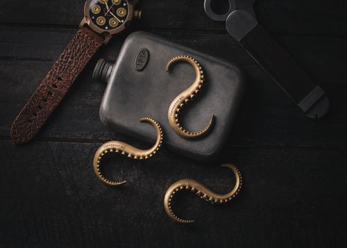 Free A dark vintage-themed still life with a flask, watch, and octopus tentacle hooks. Stock Photo