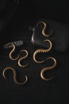 Artistic composition of ornate brass tentacle hooks and a flask, perfect for vintage decor lovers.