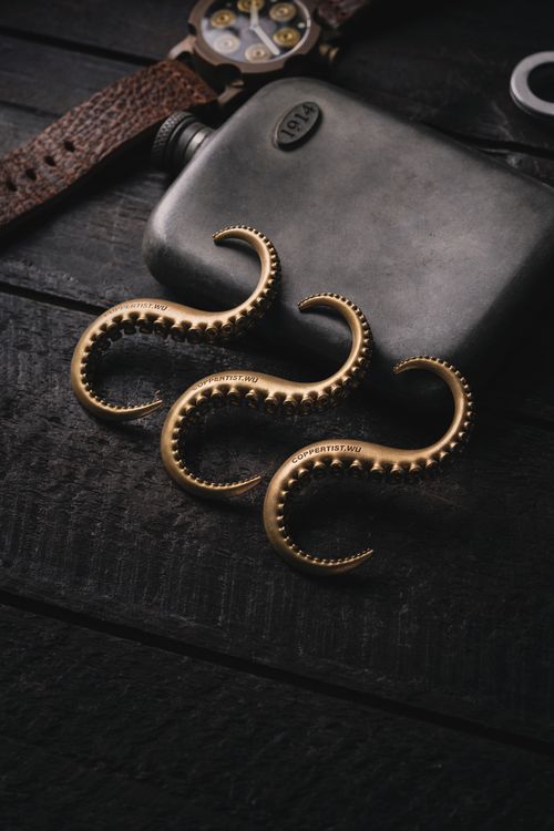 Free Stylish arrangement of golden hangers and a hip flask on a rustic wooden table. Stock Photo