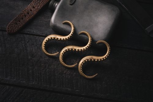 Free Close-up of a vintage copper flask with tentacle designs on a dark wooden surface, exuding nostalgia. Stock Photo