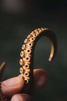 Detailed view of a brass octopus tentacle hook, showcasing vintage art deco design.