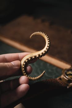 Vintage brass octopus tentacle hook held by hand, showcasing intricate design and nostalgia.