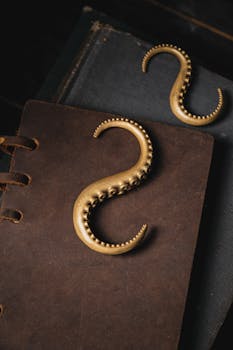 Artistic arrangement of brass octopus hooks on a vintage leather journal.