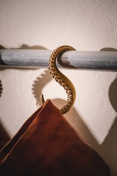 Artistic coat hanger shaped like an octopus tentacle holding a garment, adding a quirky touch to interior decor.