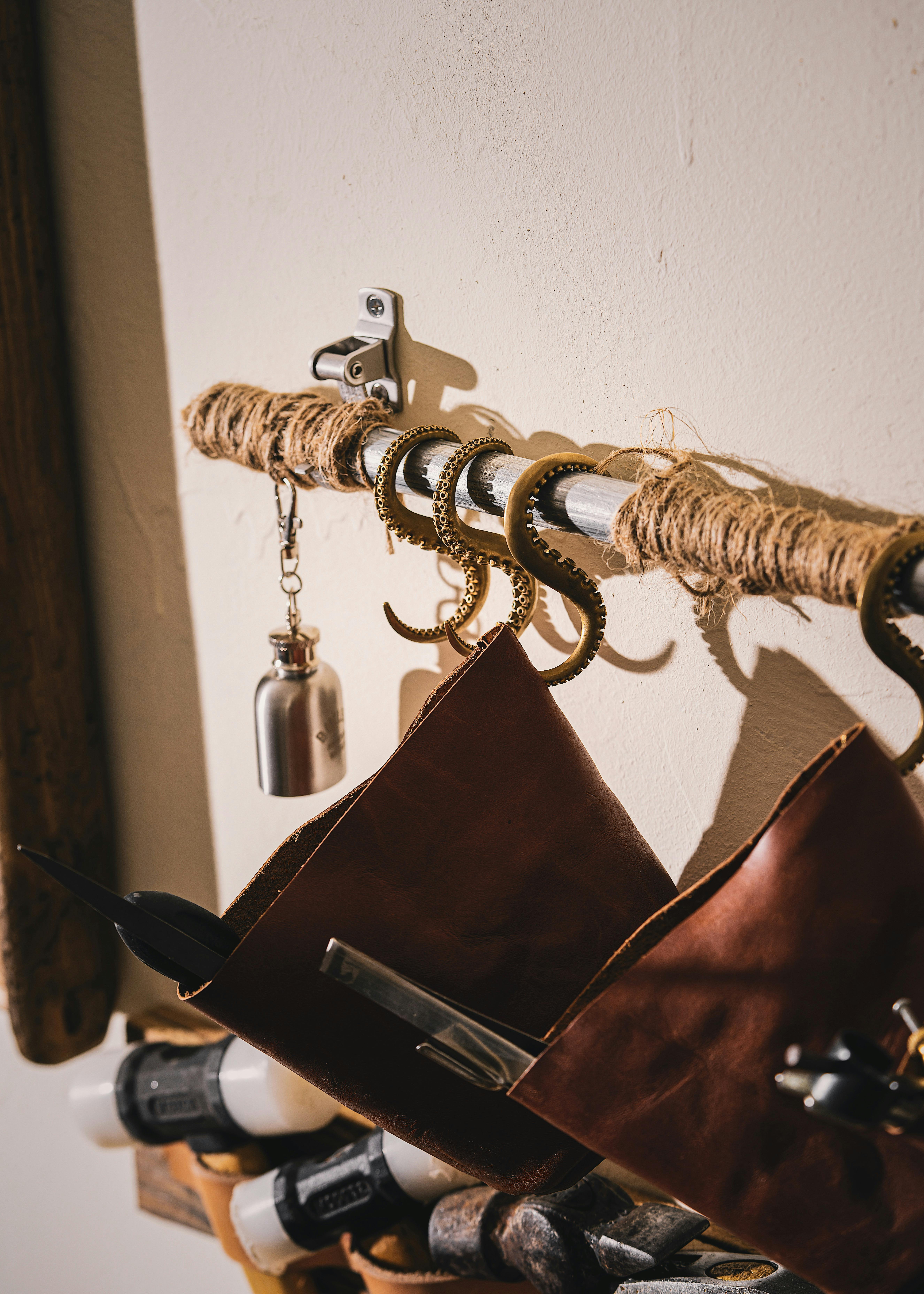 Leather Tool Bags Hanging on Octopus Tentacle Hooks · Free Stock Photo