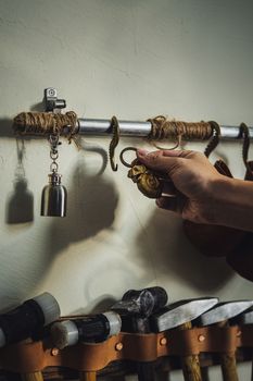 Hand reaches for vintage hook on tool rack; nostalgic craft context.