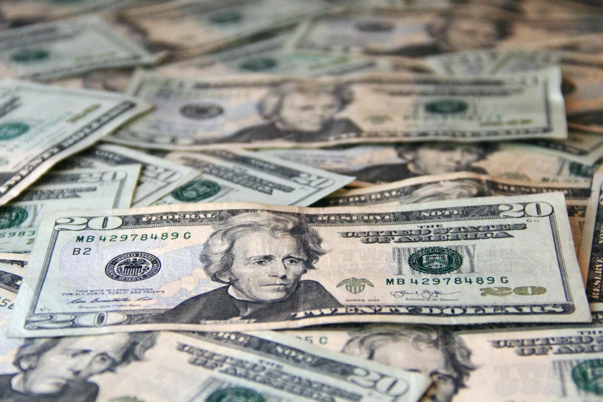 A detailed close-up of scattered US dollar bills showcasing a pile of currency.