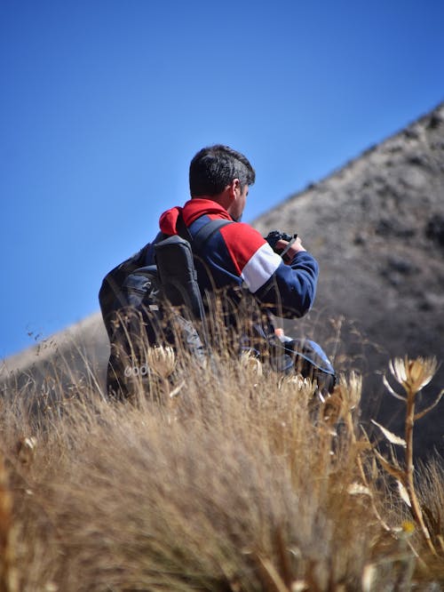 Free Backpacker Taking Photos in the Mountains  Stock Photo