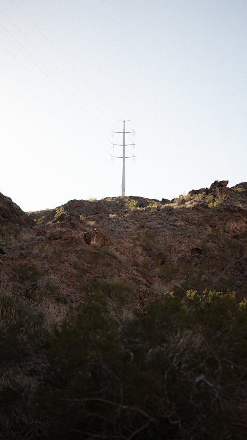 Clear Sky over Transmission Tower and Hill