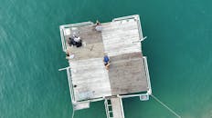 一群人在碧绿水面的木码头上享受休闲时光