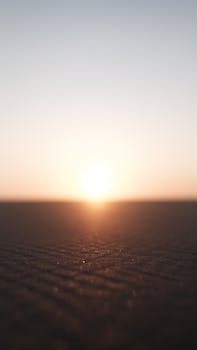 Peaceful sunset casting soft light over the vast desert horizon, emphasizing tranquility and serenity.