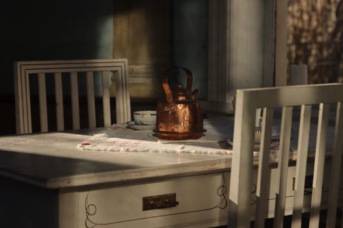 Free A cozy Swedish dining setup with a copper kettle on a vintage table. Stock Photo